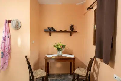 a room with a table with chairs and a vase of flowers at Villa Georgia in Kalyves