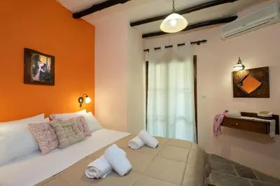 a bedroom with a large bed with orange walls at Villa Georgia in Kalyves