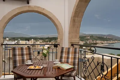 a table with a plate of food on a balcony at Villa Georgia in Kalyves