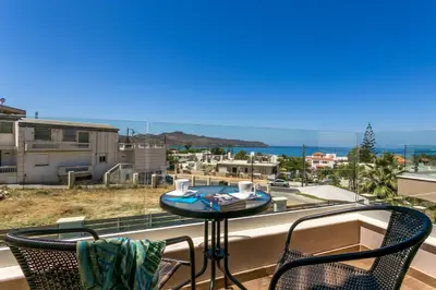 a balcony with a table and two chairs and a view of the ocean at SUPERIOR VILLA MARINA MARE Sauna - Hammam - Pool - 250m from Beach in Agia Marina Nea Kydonias