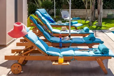 a group of lounge chairs sitting on a patio at SUPERIOR VILLA MARINA MARE Sauna - Hammam - Pool - 250m from Beach in Agia Marina Nea Kydonias