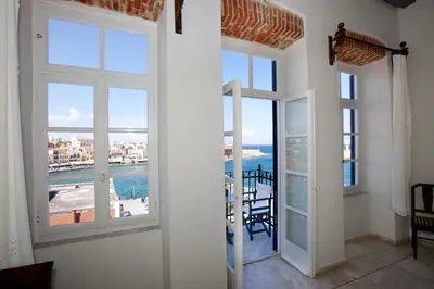 a room with windows and a view of the ocean at Suites Pandora in Chania Town