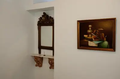 a mirror and a picture on a wall with a shelf at Suites Pandora in Chania Town