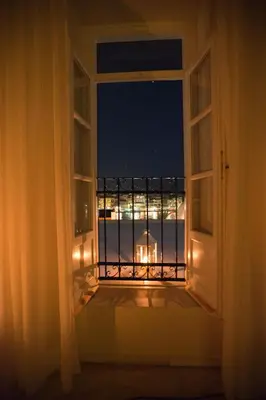an open window with a view of the ocean at night at Suites Pandora in Chania Town