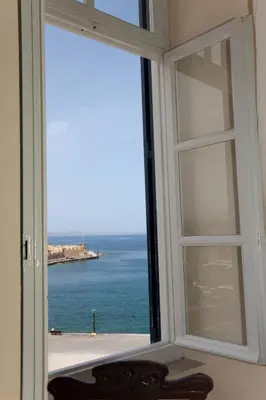 an open window with a view of the ocean at Suites Pandora in Chania Town