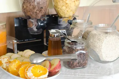 a table with a bowl of granola and jars of nuts at Nautilus Bay Hotel in Kissamos