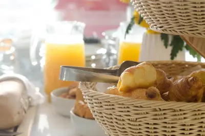 a table with baskets of bread and orange juice at Nautilus Bay Hotel in Kissamos