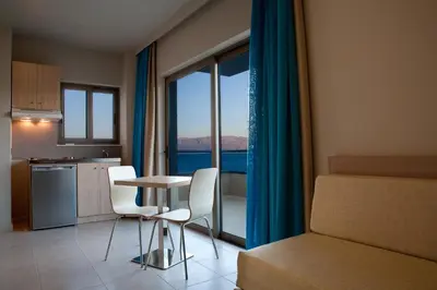 a kitchen with a table and chairs in a room with a window at Nautilus Bay Hotel in Kissamos