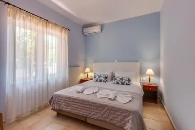 a bedroom with a bed with towels on it at Villa Armonia Chania in Kato Galatas