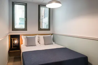 a bed in a room with two windows at The48suites in Chania Town
