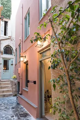a pink building with a door and stairs at The48suites in Chania Town