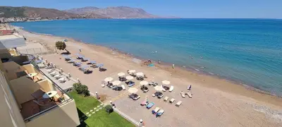 an overhead view of a beach with umbrellas and the ocean at Sunny Bay Hotel in Kissamos