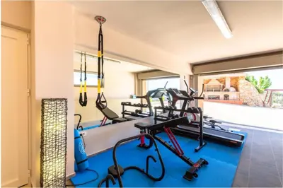 a gym with several tread machines in a room at Angel Hill Villa in Xirokámbion