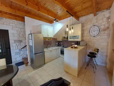 a kitchen with a refrigerator and a table and a clock at Villa Christy in Stalos