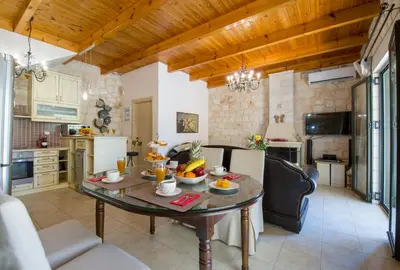 a kitchen and living room with a table with fruit on it at Villa Christy in Stalos