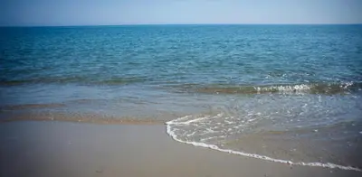 a sandy beach with the ocean in the background at Hotel Caretta Beach in Gerani Chanion