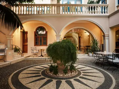 a courtyard in a building with a tree in a fountain at Casa Delfino Hotel & Spa in Chania Town