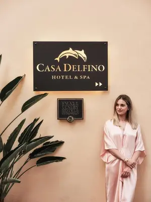 a woman standing in front of a sign on a wall at Casa Delfino Hotel & Spa in Chania Town