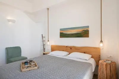 a bedroom with a bed and a blue chair at Casa le Cicale in Falasarna