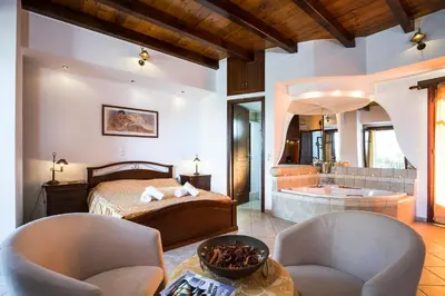 a bedroom with a bed and a tub in a room at Pericles Beach Villa in Kissamos
