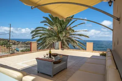 a patio with a view of the ocean at Pericles Beach Villa in Kissamos