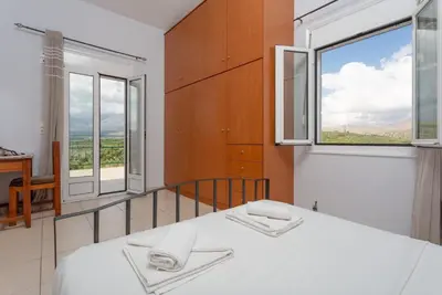 a bedroom with a bed and a large window at Villa Giannis in Áyios Andónios