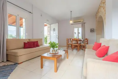 a living room with two couches and a table at Villa Giannis in Áyios Andónios