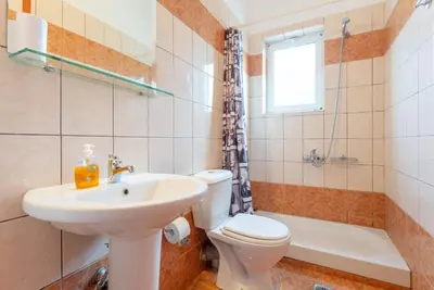 a bathroom with a sink and a toilet and a window at Villa Giannis in Áyios Andónios