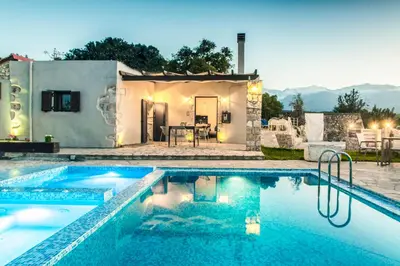 a villa with a swimming pool in front of a house at Minos Villa in Arménoi