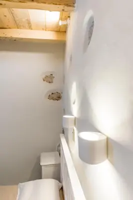 a white bathroom with a toilet and a sink at Minos Villa in Arménoi