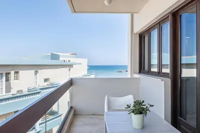 a balcony with a table and a view of the ocean at Magia Apartments in Chania Town