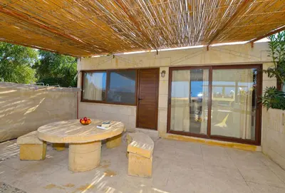 a patio with a table and benches and a building at Anemomili Village in Kissamos