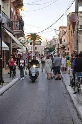 a man riding a motorcycle down a busy city street at Kydonia Rooms in Chania Town