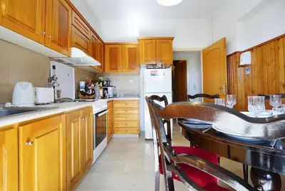 a kitchen with wooden cabinets and a table with chairs at Sunhouse-CH in Chania Town