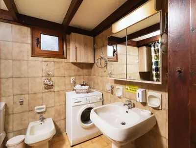 a bathroom with a washing machine and a sink at Wooden Beach House in Gerani Chanion