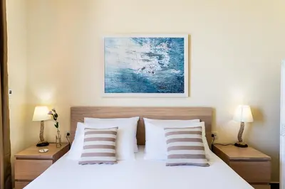 a bedroom with a bed with two lamps and a painting at Villa Kudos in Maleme