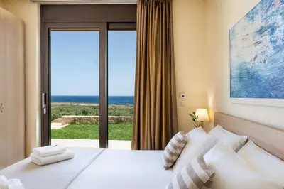 a bedroom with a bed with a view of the ocean at Villa Kudos in Maleme