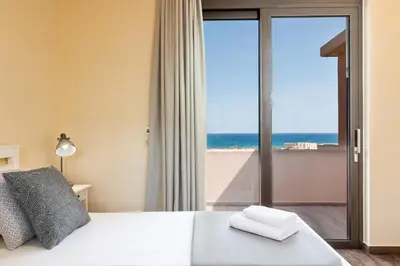 a bedroom with a bed with a view of the ocean at Villa Kudos in Maleme