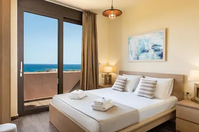 a bedroom with a bed with a view of the ocean at Villa Kudos in Maleme