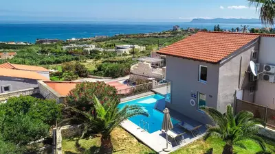 an aerial view of a house with a swimming pool and the ocean at Lofos Village Chania in Agia Marina Nea Kydonias