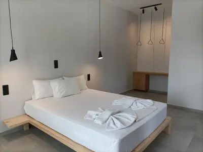 a bedroom with a white bed with two towels on it at Galini Studios & Apartments-Adults only in Sougia