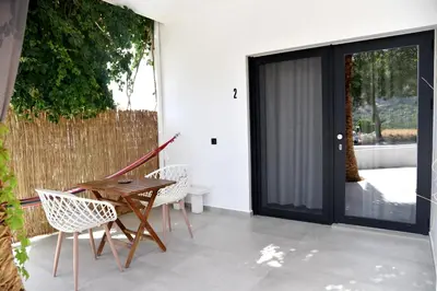 a patio with two chairs and a wooden table at Galini Studios & Apartments-Adults only in Sougia