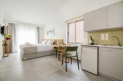 a kitchen and a bedroom with a bed and a table at Lotus Hotel Apartments in Kato Daratso