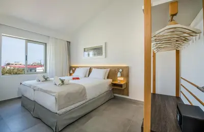 a bedroom with a large bed and a window at Lotus Hotel Apartments in Kato Daratso