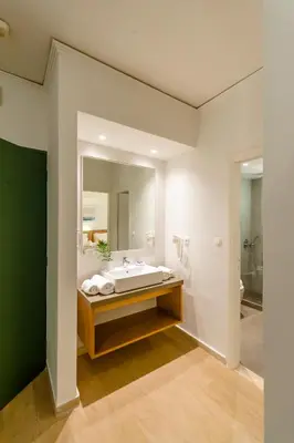 a bathroom with a large mirror and a bath tub at Lotus Hotel Apartments in Kato Daratso