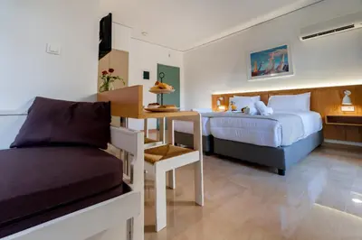 a bedroom with a bed and a table and a desk at Lotus Hotel Apartments in Kato Daratso