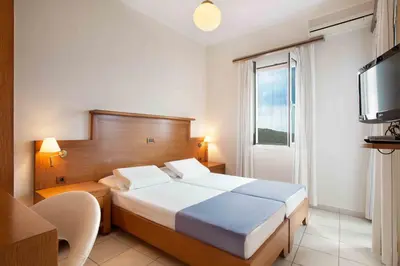 a hotel room with a bed and a television at Giorgi's Blue Apartments in Kalathas
