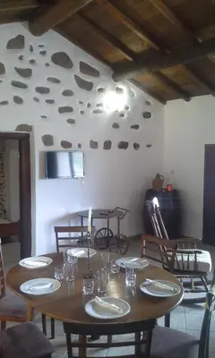 a dining room with a table with plates and glasses at Traditional House Koukounara in Kissamos