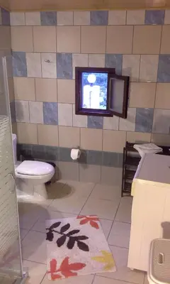 a bathroom with a toilet and a tv on the wall at Traditional House Koukounara in Kissamos
