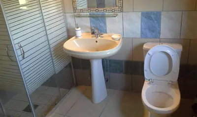 a bathroom with a sink and a toilet and a mirror at Traditional House Koukounara in Kissamos